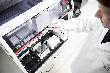 a person opening the door of a CyBio Felix liquid handler